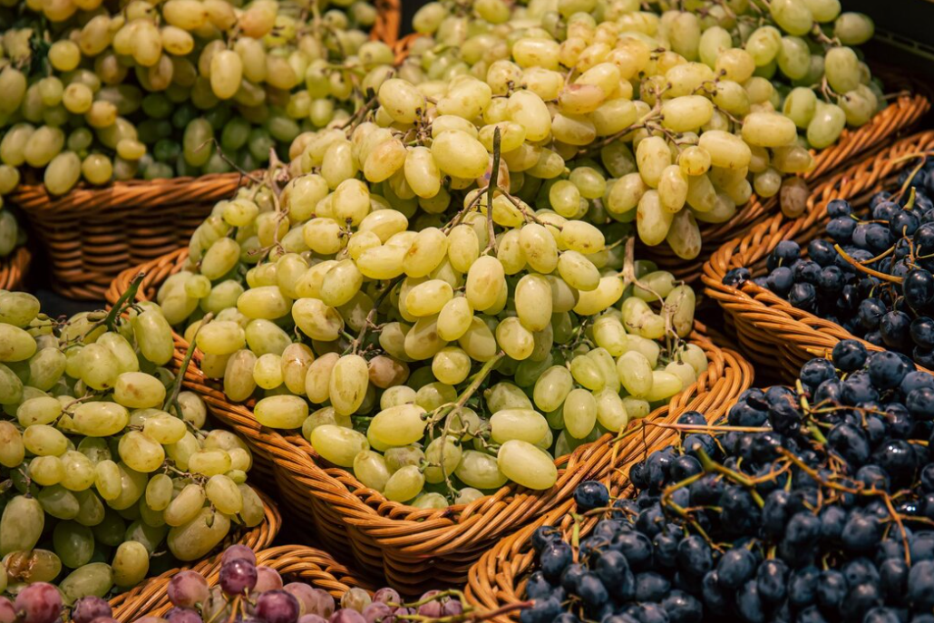 Baskets with green, purple, and pink types of grapes